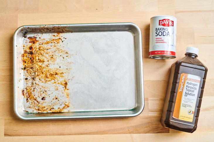 half cleaned baking sheet with hydrogen peroxide and baking soda