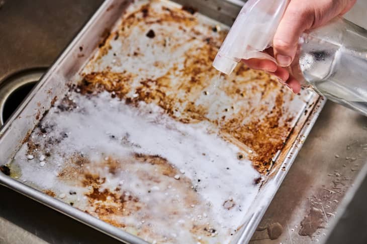 spraying hydrogen peroxide onto a baking sheet covered in baking soda